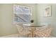 Bright breakfast nook with glass table and four white chairs at 1328 Siesta Bayside Dr # 1328-C, Sarasota, FL 34242