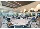 Large clubhouse dining area offering many tables, cutlery settings, ample seating, pendant lights, and outside views at 15625 San Lazzaro Ave, Bradenton, FL 34211