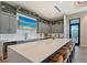 Modern kitchen with a large quartz island, bar stool seating, a wine fridge, and lots of cabinet storage at 15625 San Lazzaro Ave, Bradenton, FL 34211