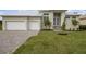 House exterior showcasing a light beige color scheme, white garage doors, and landscaping at 16381 Cape Horn Blvd, Punta Gorda, FL 33955
