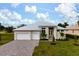 Two-story house with light beige walls, white garage doors, and a paved driveway at 16381 Cape Horn Blvd, Punta Gorda, FL 33955