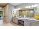 Double vanity bathroom with granite countertops and a large mirror at 16431 Star Grass Cir, Bradenton, FL 34211