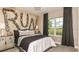 Relaxing bedroom with a large window, gray bedding, and a unique wall decor at 16443 Star Grass Cir, Bradenton, FL 34211