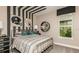 Bright bedroom with a metal bed frame and a striped accent wall at 16443 Star Grass Cir, Bradenton, FL 34211