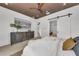 Bedroom with wood ceiling, sliding barn door, and view into a modern bathroom at 2038 Datura St, Sarasota, FL 34239