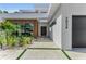 Contemporary home exterior with modern landscaping, concrete walkway with grass inserts, and dark wood accents at 2038 Datura St, Sarasota, FL 34239
