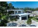 Aerial view of a modern, two-story home with flat roof, lush greenery, and a unique driveway at 2038 Datura St, Sarasota, FL 34239