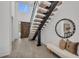 Modern foyer with open staircase, high ceilings, and a stylish bench with pillows at 2038 Datura St, Sarasota, FL 34239
