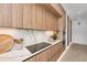 Modern kitchen featuring sleek wooden cabinets, marble backsplash, and stainless steel appliances at 2038 Datura St, Sarasota, FL 34239