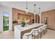 Bright kitchen with a marble island, wooden cabinets, pendant lights, and modern appliances at 2038 Datura St, Sarasota, FL 34239