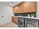 Modern laundry room with wood cabinets, white countertops, and updated washer and dryer at 2038 Datura St, Sarasota, FL 34239