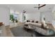 Open-concept living room with hardwood floors, modern sofa, and a view of the office through glass doors at 2038 Datura St, Sarasota, FL 34239