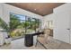 Bright office space with a large window showcasing the lush landscaping and wood paneled ceiling at 2038 Datura St, Sarasota, FL 34239