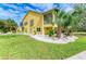 Two-story house with yellow exterior, screened porch, and lush landscaping at 2501 Broad St, Nokomis, FL 34275