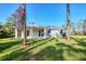 House exterior showcasing a covered patio and grassy yard at 2814 Daphne Rd, North Port, FL 34288