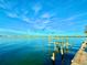 Waterfront view featuring a weathered dock with a boat lift and the distant city skyline at 3200 Higel Ave, Sarasota, FL 34242