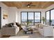 Relax in this open living room with modern furnishings, wood ceiling, and expansive ocean views at 3200 Higel Ave, Sarasota, FL 34242