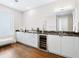 Modern wet bar with granite countertop, wine cooler, and white cabinetry at 540 N Tamiami Trl # 1201, Sarasota, FL 34236