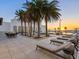 Inviting pool area with lounge chairs, palm trees, and sunset views at 540 N Tamiami Trl # 1201, Sarasota, FL 34236