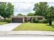 Tan one-story house with brown garage door and landscaped yard at 7126 Sonata Dr, Port Richey, FL 34668