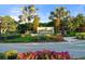 Entrance to Esplanade at Palmer Ranch, featuring a stone sign and lush landscaping at 12413 Parigi Way, Sarasota, FL 34238