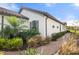 A walkway alongside a white stucco house with a brown tile roof at 12413 Parigi Way, Sarasota, FL 34238