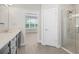 Modern bathroom with double vanity, walk-in shower, and access to a bedroom at 12413 Parigi Way, Sarasota, FL 34238