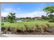 Backyard view of pond, landscape, and other homes at 12413 Parigi Way, Sarasota, FL 34238