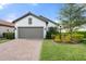 Single-story home with a two-car garage and well-manicured landscaping at 12413 Parigi Way, Sarasota, FL 34238