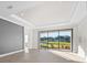Bright living room with large sliding glass doors and water view at 12413 Parigi Way, Sarasota, FL 34238