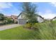 Two-car garage with gray doors and landscaping at 12413 Parigi Way, Sarasota, FL 34238