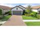 An aerial view of a single story home with a paved driveway and surrounding landscape at 12413 Parigi Way, Sarasota, FL 34238