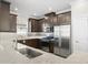 Modern kitchen with dark brown cabinets and granite countertops at 12413 Parigi Way, Sarasota, FL 34238