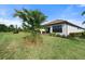 Landscaped backyard with lush grass and a tree at 12413 Parigi Way, Sarasota, FL 34238