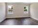 Simple bedroom with dark hardwood floors and two windows at 1637 Hyde Park St, Sarasota, FL 34239