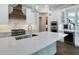 Modern kitchen with stainless steel appliances, white cabinetry, and a large island with quartz countertops at 1637 Hyde Park St, Sarasota, FL 34239