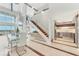 Open concept dining area with a glass table, white chairs, and modern staircase at 1990 Main St # 15, Sarasota, FL 34236