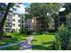 Landscaped exterior view of building with walkway, mature trees and shrubbery at 315 30Th W Ave # B311, Bradenton, FL 34205