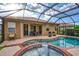 Lush backyard oasis featuring a screened pool, spa, and lake view at 335 River Enclave Ct, Bradenton, FL 34212