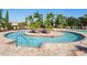 Circular pool with surrounding lounge chairs and plants at 335 River Enclave Ct, Bradenton, FL 34212