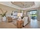 Bright living room featuring a comfortable sofa, wicker chairs, and a view of the backyard at 4612 Stickley Ct, Palmetto, FL 34221