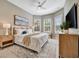 Bright bedroom with king-size bed, window seat, and large window with plantation shutters at 4612 Stickley Ct, Palmetto, FL 34221