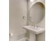 Small powder room with pedestal sink and round mirror at 5364 Salcano St, Sarasota, FL 34238