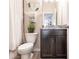This half bathroom features a dark wood vanity with granite counters and modern fixtures at 8256 Enclave Way # 101, Sarasota, FL 34243