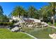 Community entrance with lush landscaping, water feature, and clear signage under a vibrant blue sky at 8256 Enclave Way # 101, Sarasota, FL 34243