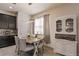 Bright dining area features a modern light fixture, wood table with gray upholstered chairs, and white hutch at 8256 Enclave Way # 101, Sarasota, FL 34243