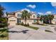 Attractive townhome complex featuring well-manicured lawns, mature palm trees, and tile roofs at 8256 Enclave Way # 101, Sarasota, FL 34243