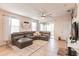Spacious living room with gray sectional sofa, large windows, and ceiling fan at 8256 Enclave Way # 101, Sarasota, FL 34243