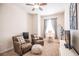 Cozy bedroom with two armchairs, a TV, and a ceiling fan at 8256 Enclave Way # 101, Sarasota, FL 34243