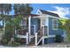 Charming beach cottage with a pergola-covered deck and landscaping at 114 31St St, Holmes Beach, FL 34217